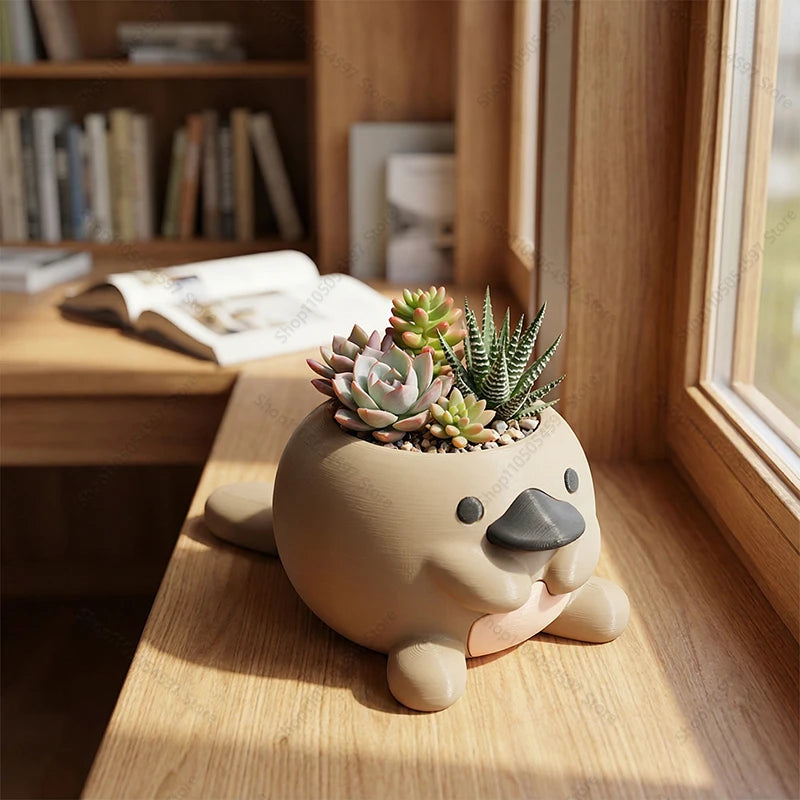platypus-shaped succulent planter on a wooden desk near a window with books in background