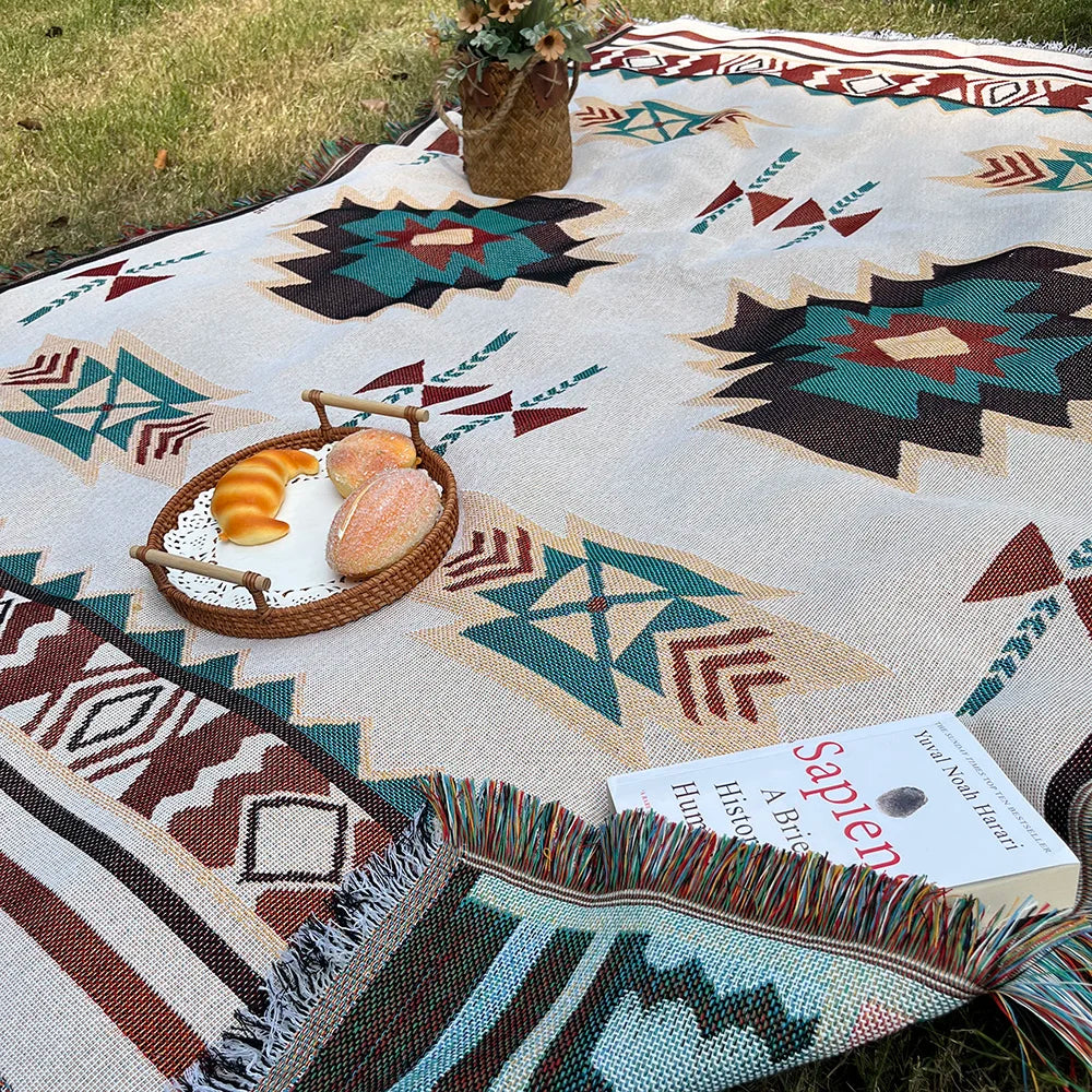 Woven Aztec throw blanket in use as a picnic blanket on grass