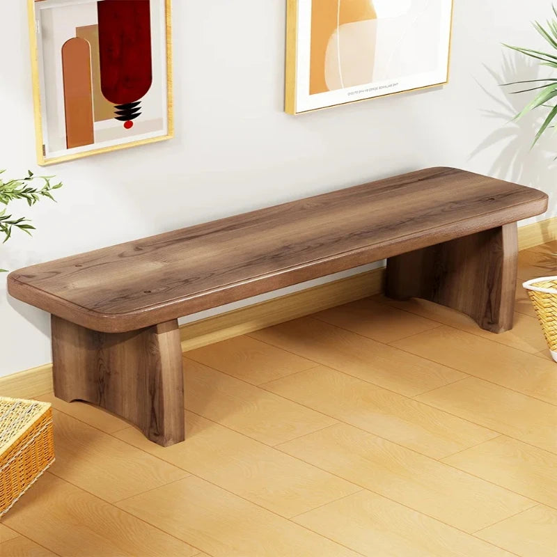 solid wood bench placed against a wall in a bright entryway with modern decor