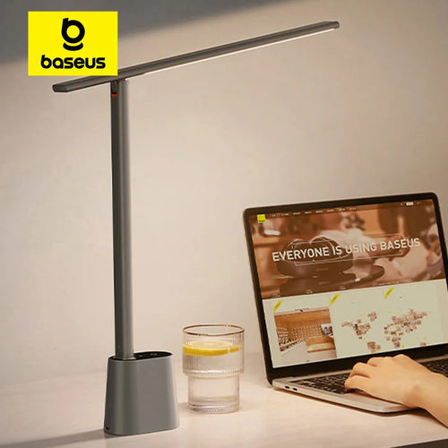 Grey rechargeable LED desk lamp on a home office desk beside a glass of water and laptop