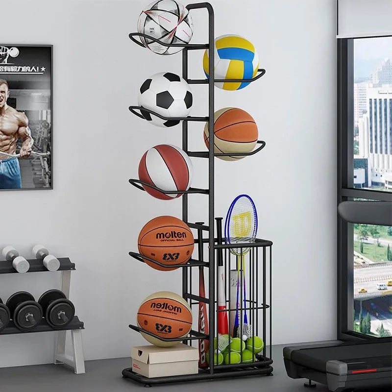 Black metal ball and equipment rack holding balls and rackets in a home gym next to weights
