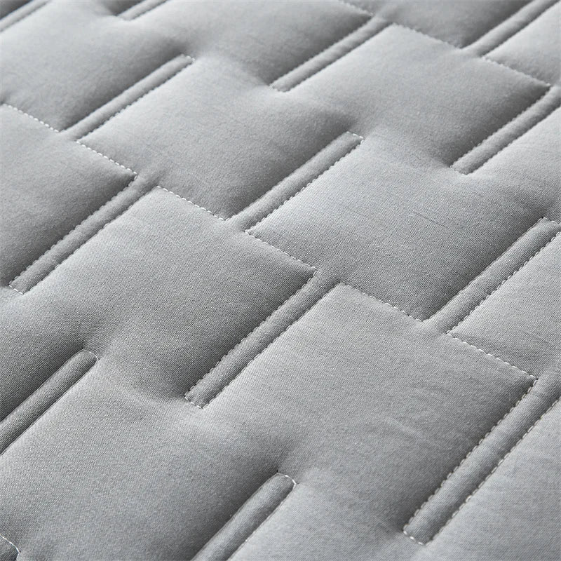 Close-up of gray cloud stitch quilted blanket fabric texture