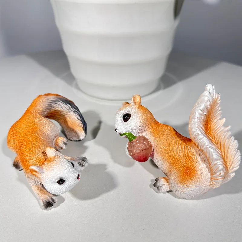 Two resin squirrel figures shown next to a white planter