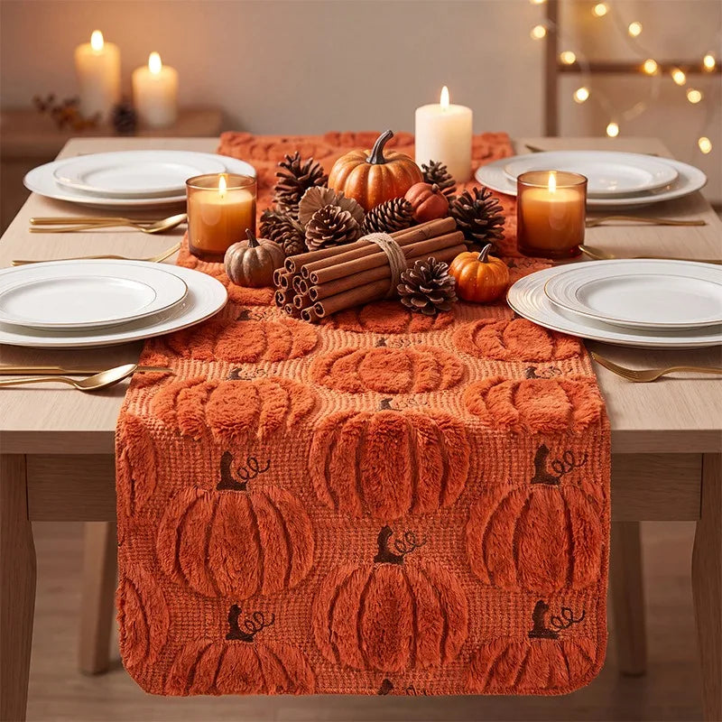 Pumpkin knit table runner styled with cinnamon sticks, pine cones, and autumn candles