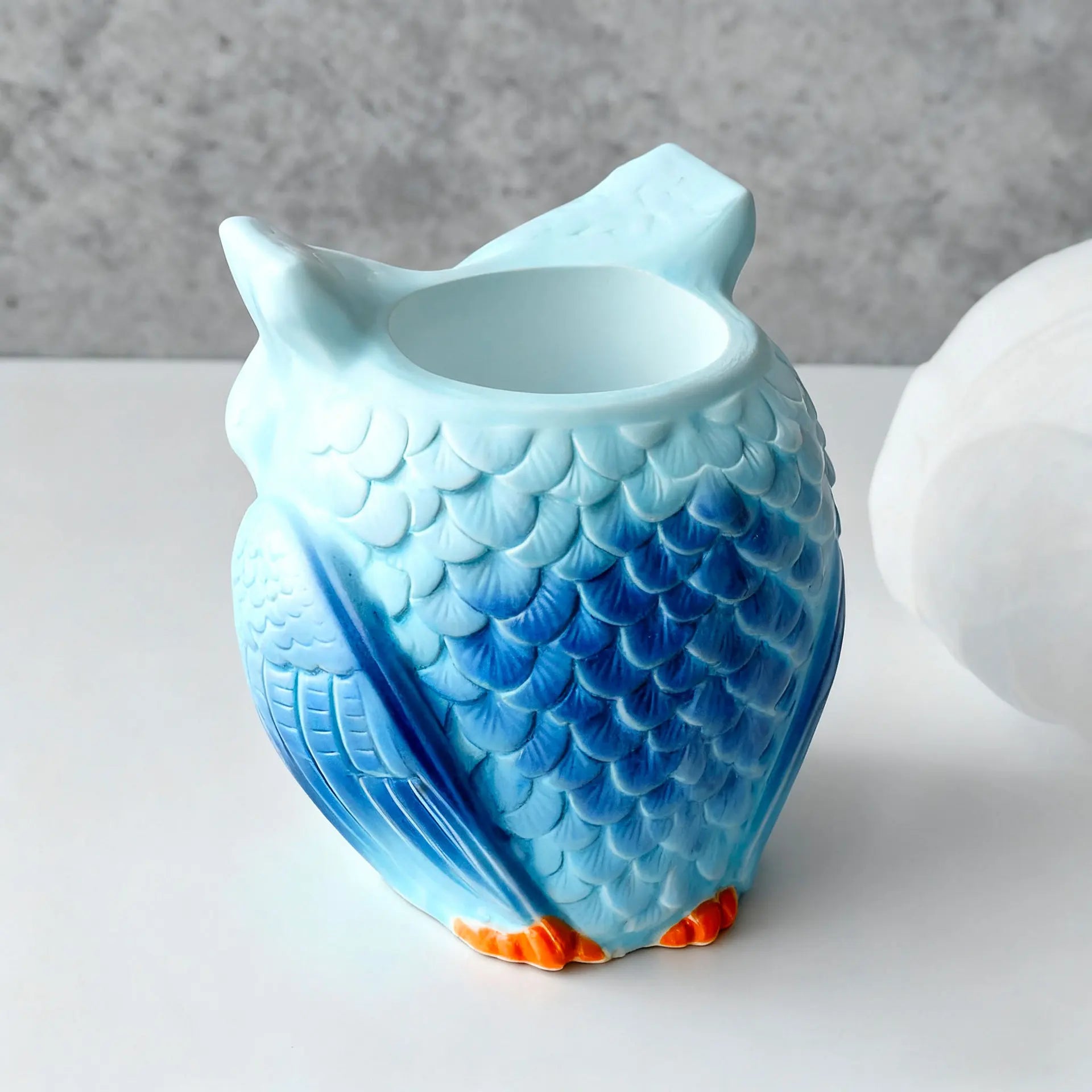 Blue gradient owl-shaped planter viewed from the side