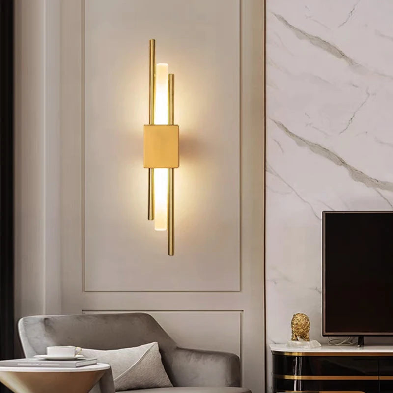Gold LED wall sconce lighting up living area near TV and armchair