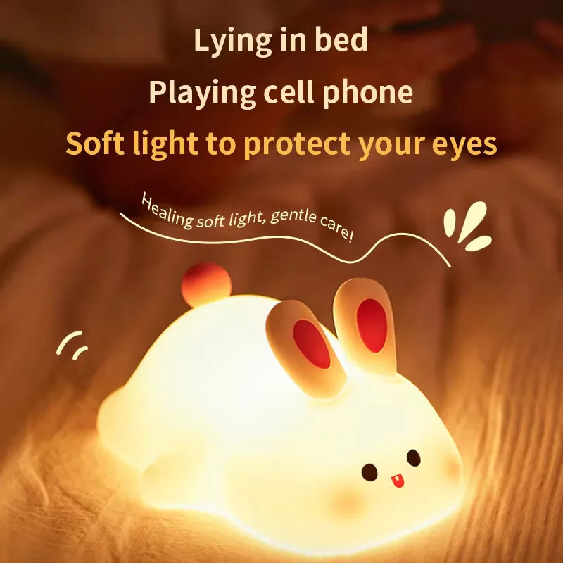 Bunny silicone night light emitting a gentle glow on a bed
