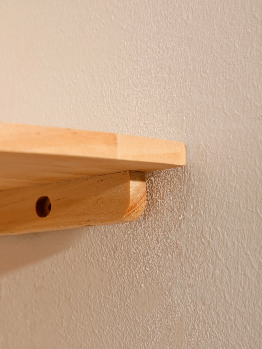 Side view of scalloped wooden corner wall shelf showing bolt-in mounting bracket detail