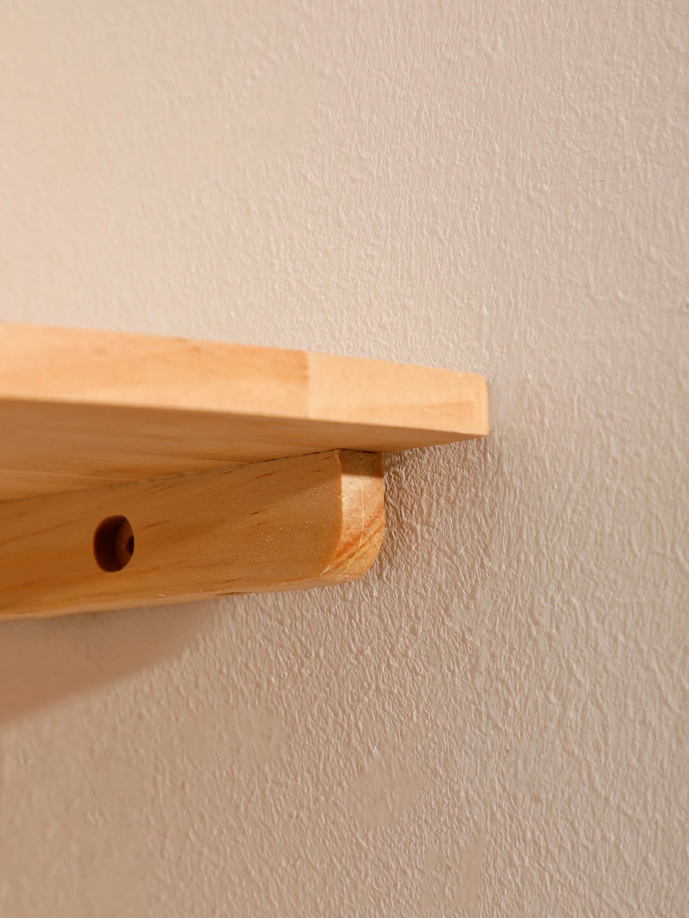 Side view of scalloped wooden corner wall shelf showing bolt-in mounting bracket detail