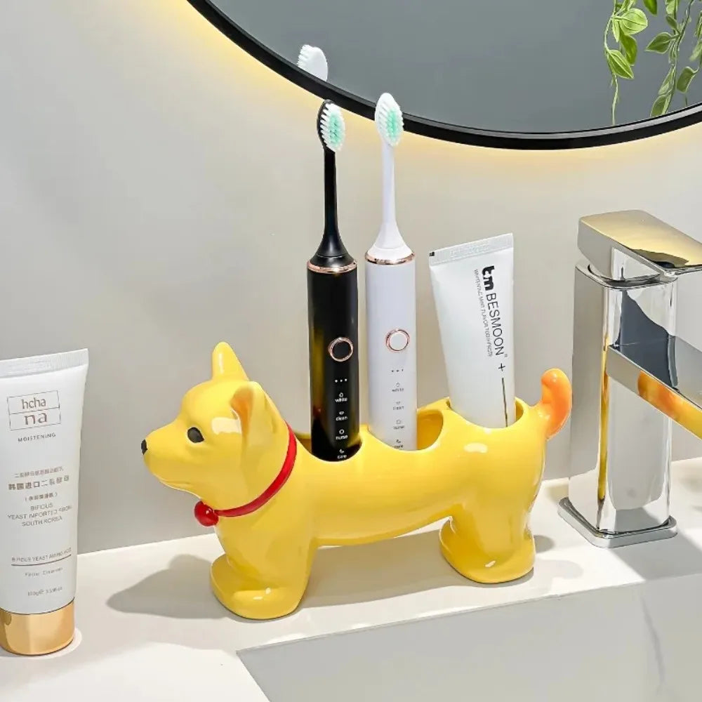 Yellow dog-shaped ceramic toothbrush holder on a bathroom counter, organized with two electric toothbrushes and a tube