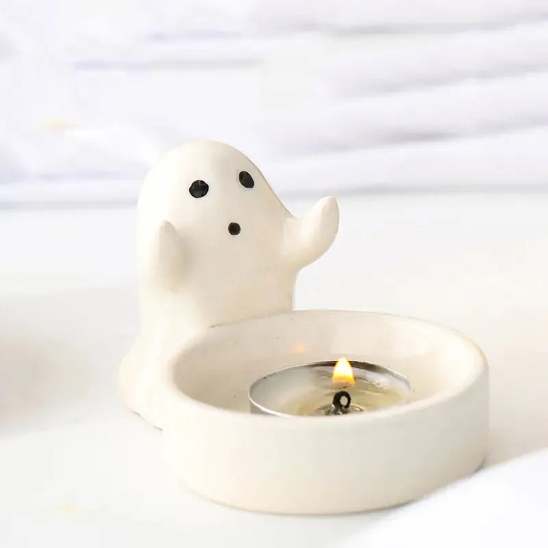 single ghost-shaped ceramic candle holder with a lit tea light