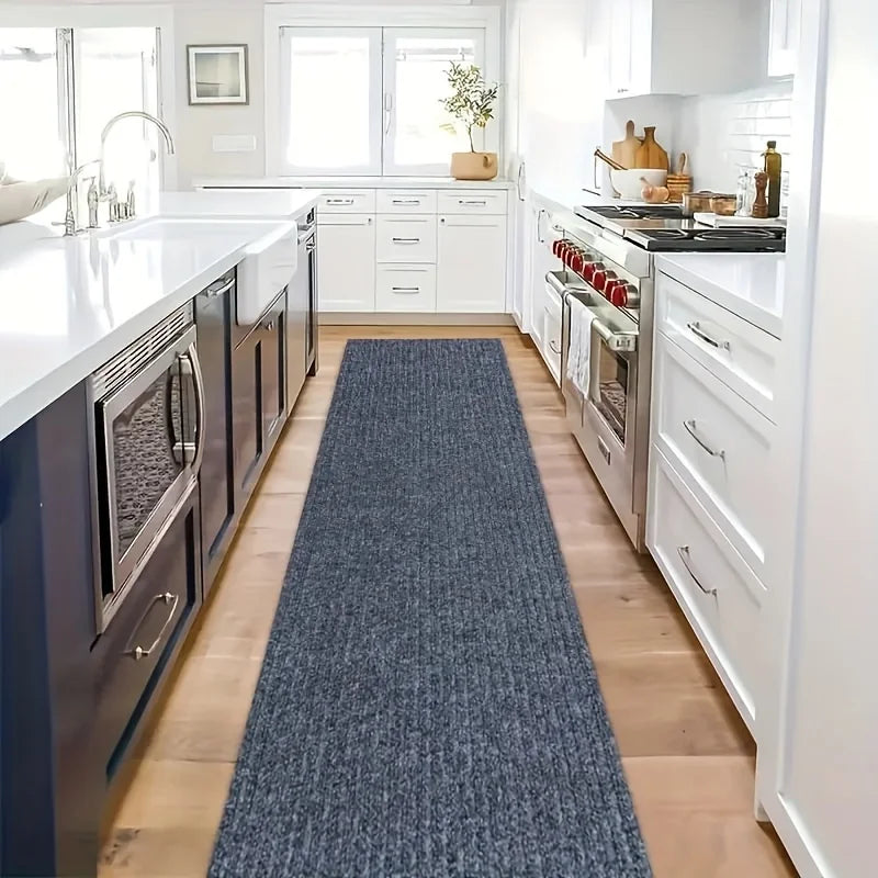 Dark grey self-adhesive runner rug placed in a long kitchen galley