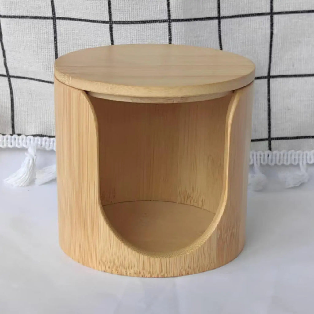 Front-facing view of an empty round bamboo cotton pad holder with open front