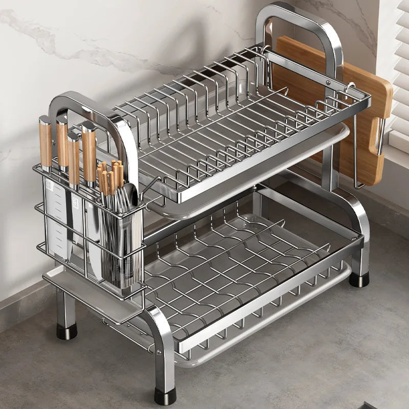 Two-tier metal dish drying rack on kitchen counter with utensil and board holder
