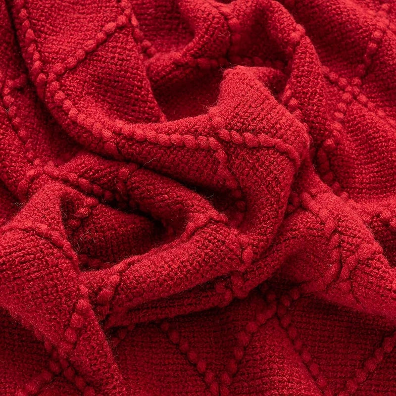 Close-up of red acrylic knit blanket showing textured diamond pattern
