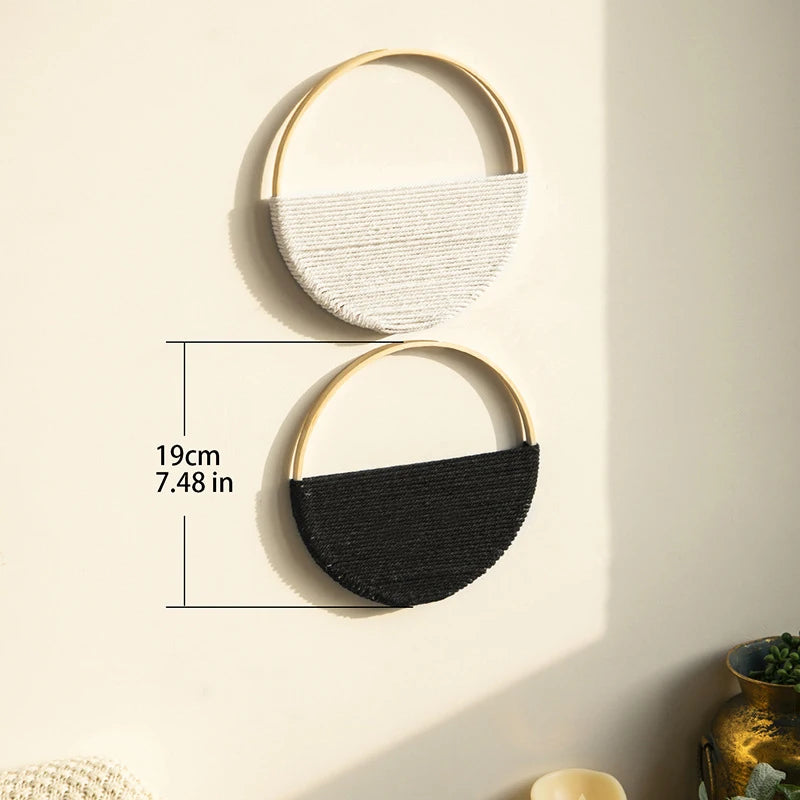 Two round woven macrame wall hangings, white and black color, on wall with 19cm measurement for scale