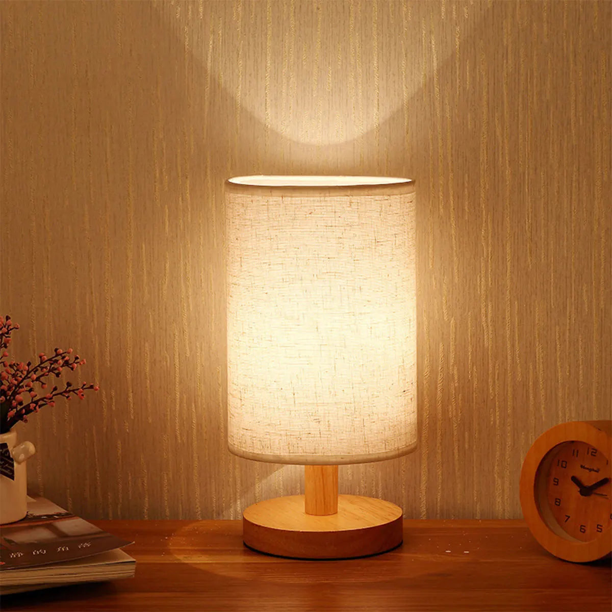 USB bedside lamp with linen cylinder shade glowing on a wood nightstand