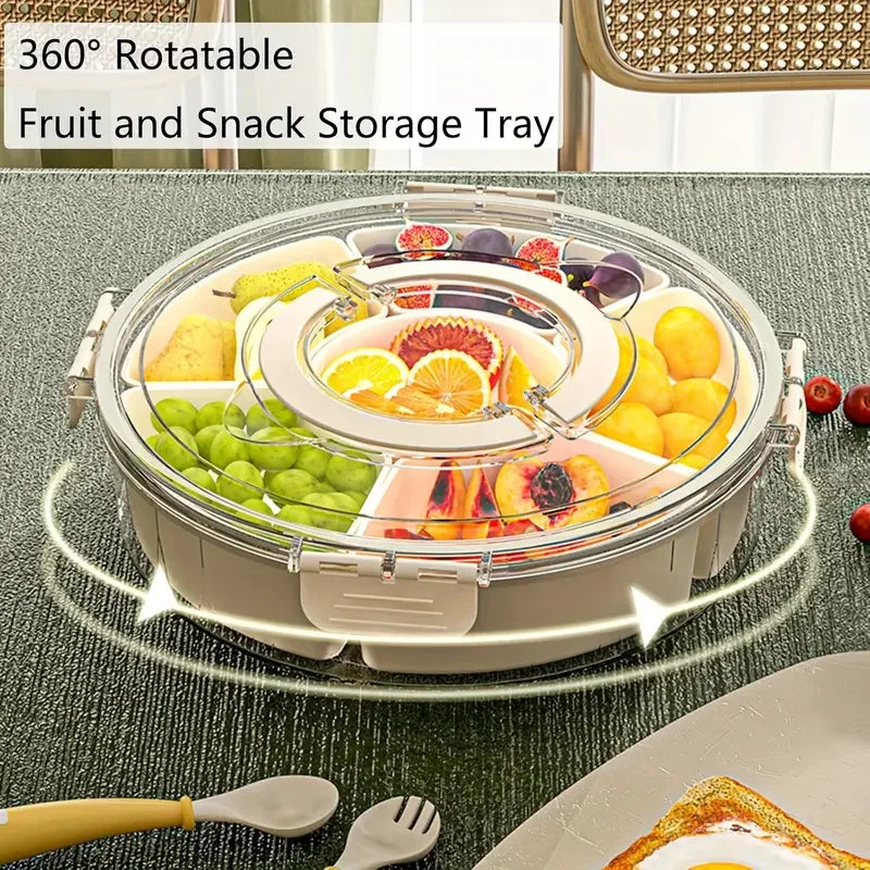 Round divided rotating snack tray with lid, filled with fruit and set on a dining table