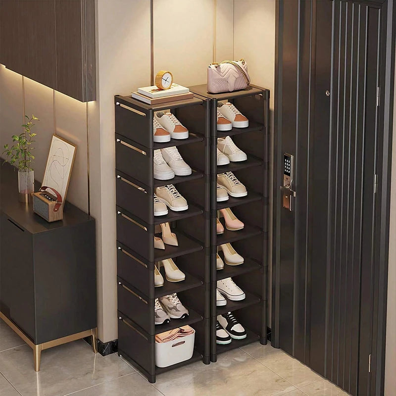 Pair of tall narrow black metal shoe racks used in a small entryway beside the door, filled with shoes.