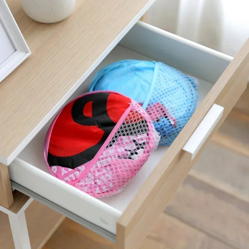 Two mesh pop-up hampers folded flat and stored in a drawer