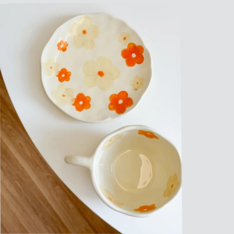 Close-up of orange floral hand-painted ceramic plate and matching cup