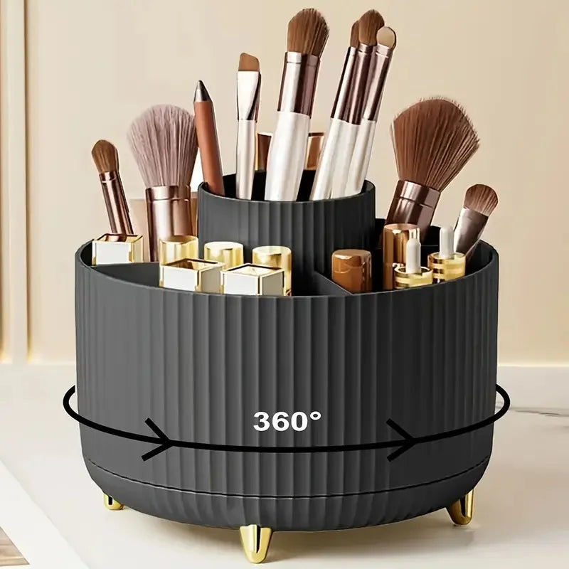 Round black rotating makeup brush organizer with gold feet holding makeup brushes and cosmetics on a vanity