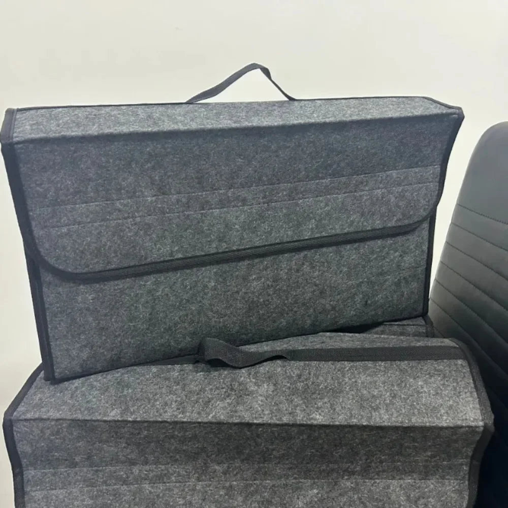 Two gray felt trunk storage organizer bags displayed stacked on a chair