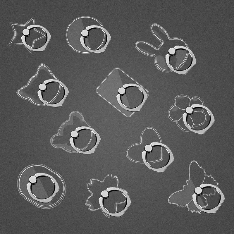 Clear animal and geometric shaped phone ring holders on a dark background