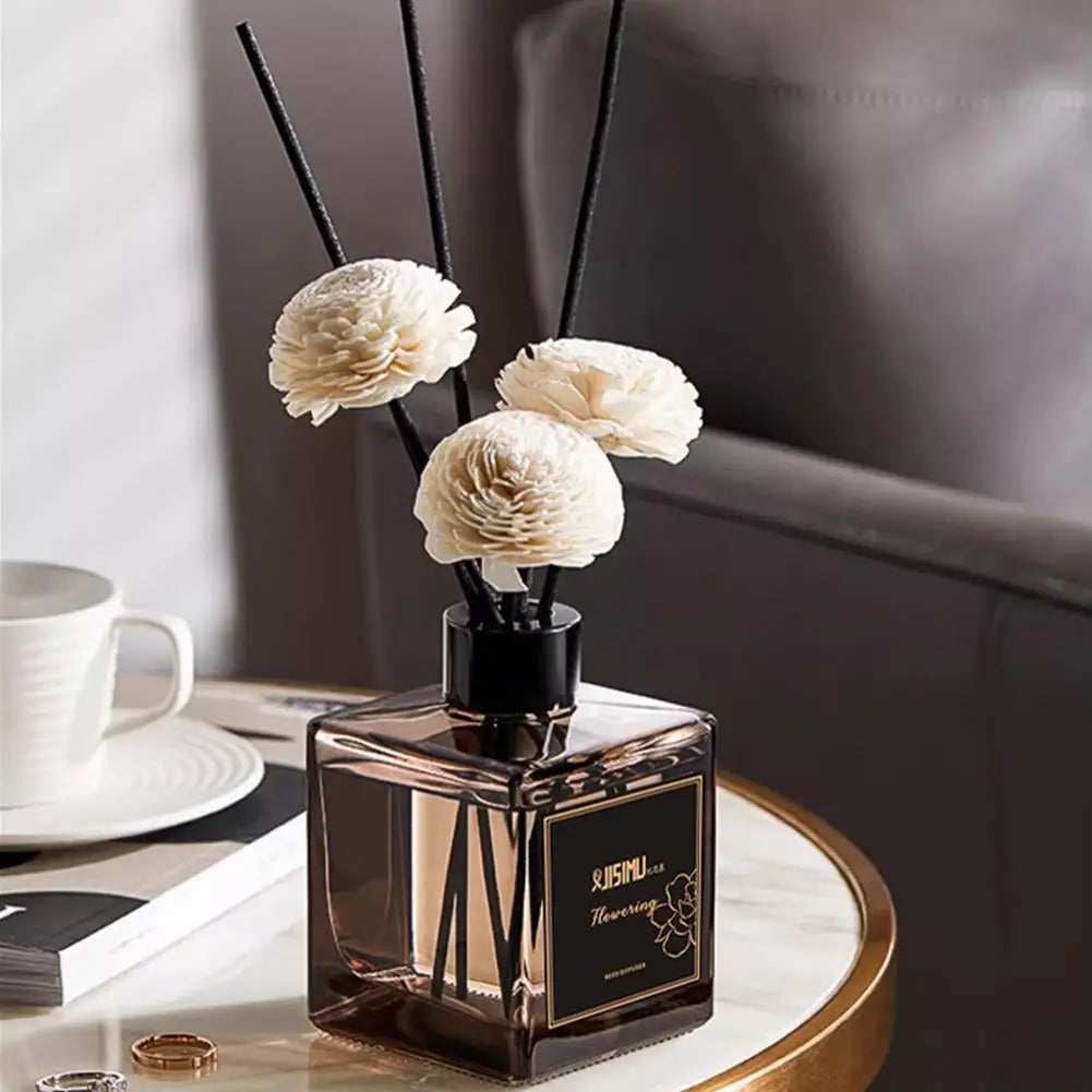 Reed diffuser with jasmine scent and decorative sticks on a living room side table