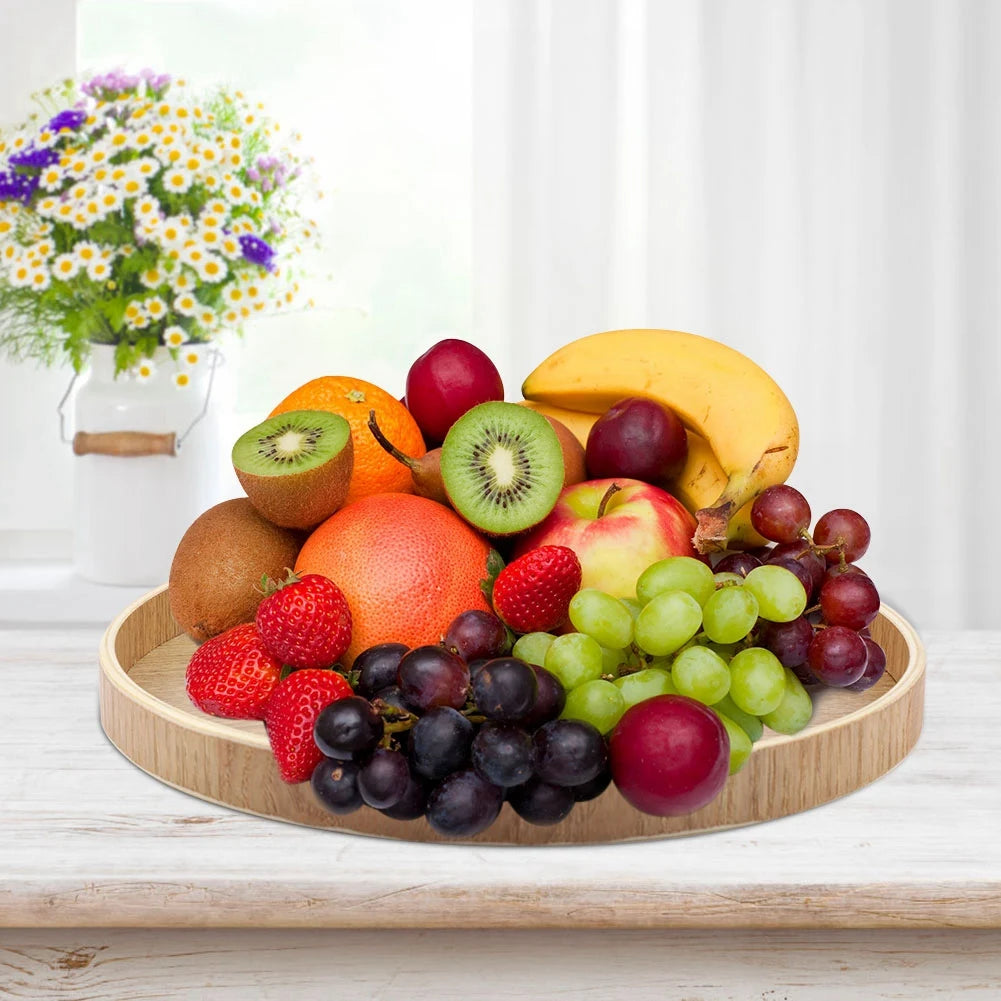 Round wooden tray on kitchen table holding assorted fresh fruit