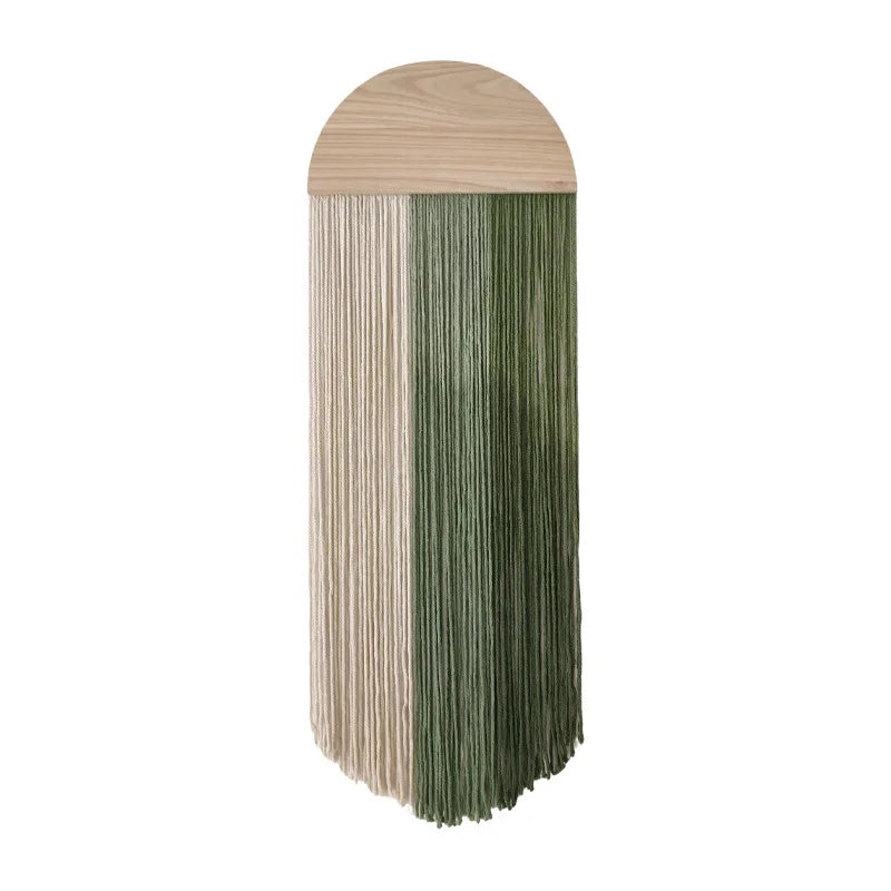 Close-up of green and cream woven tassel wall hanging with wooden arch