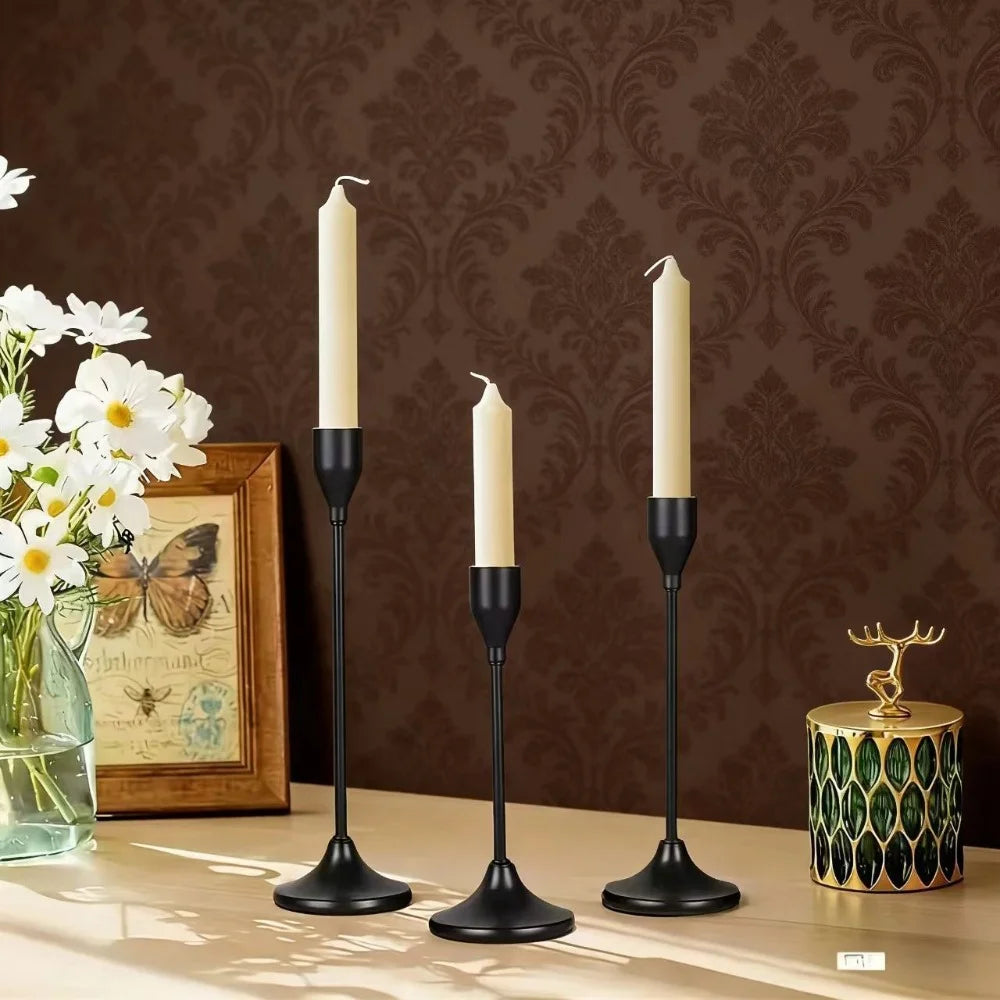 Black metal candle holder set with taper candles placed on a wooden side table in a living room