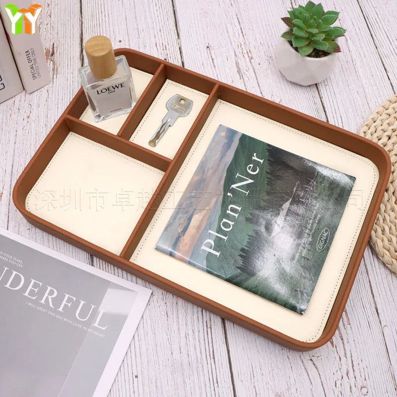 Wooden catchall tray with small compartments storing a key, bottle, and planner on a desk