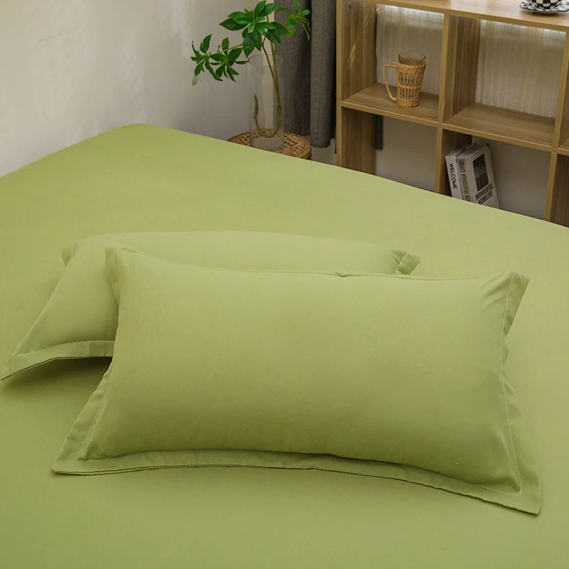 Solid color light green pillowcases on a matching bed with wooden shelving