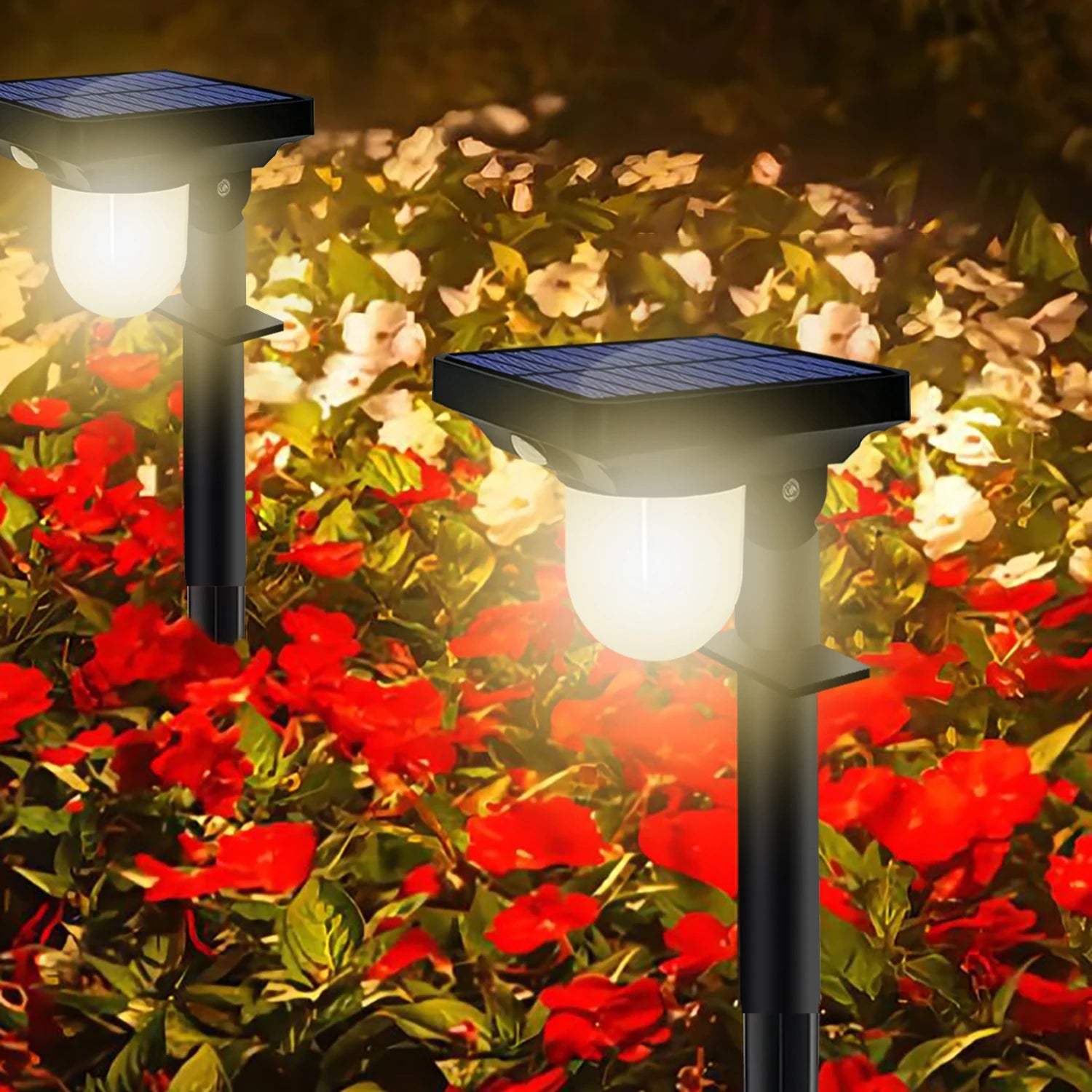 Two solar motion sensor pathway lights illuminating a flower bed in a garden at night