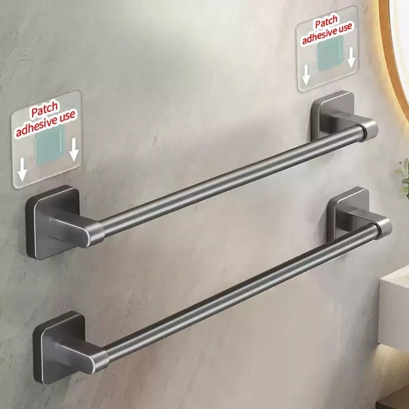 Gray adhesive towel bars mounted on a tiled bathroom wall