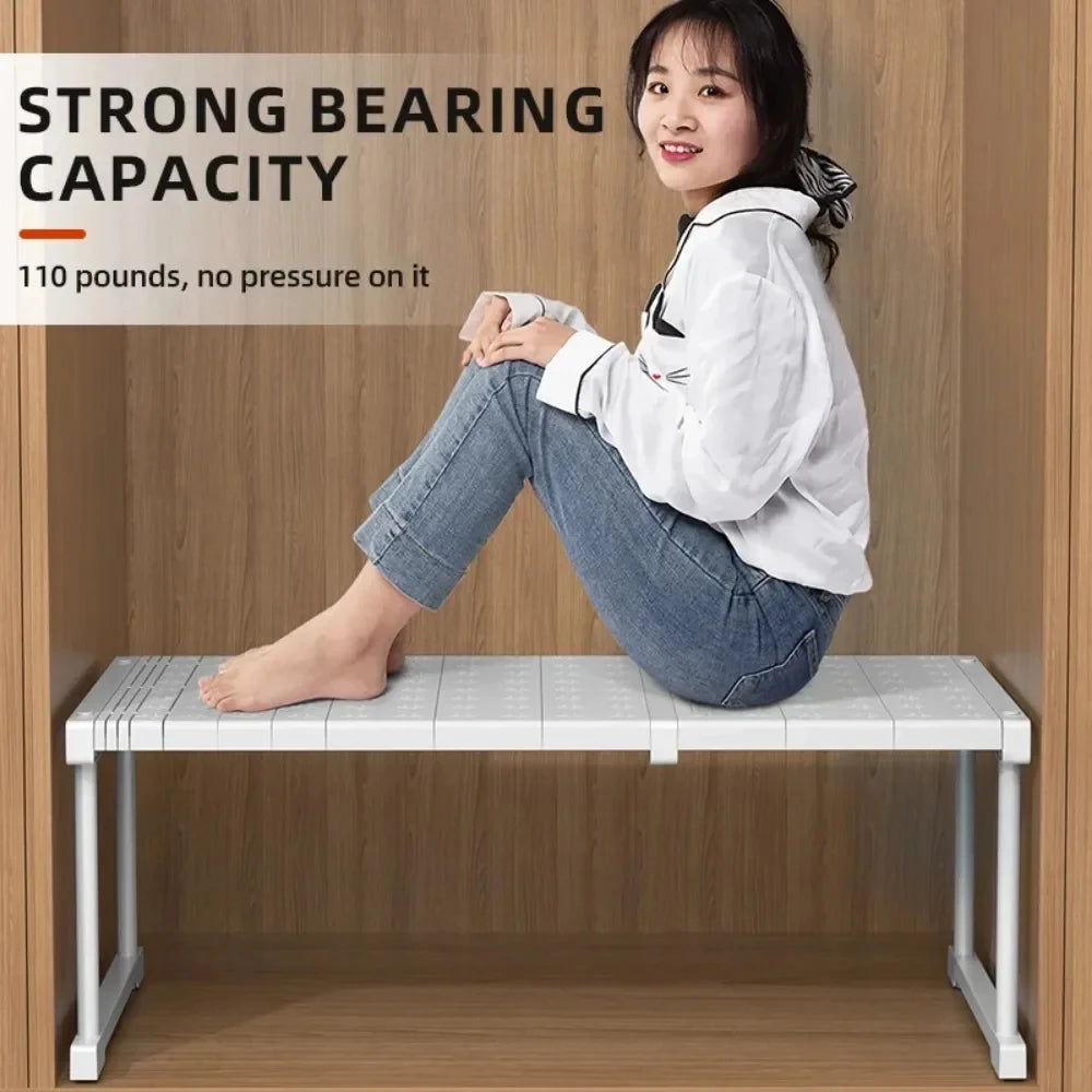 Person sitting on an adjustable stackable closet shelf divider inside a wooden wardrobe