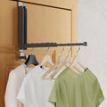 folding over-the-door drying rack holding hangers and clothes in a bedroom or laundry space