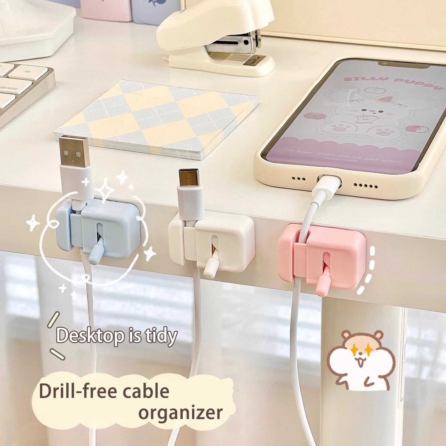Blue, white, and pink no-drill cable clips holding charging cords neatly along a desk edge
