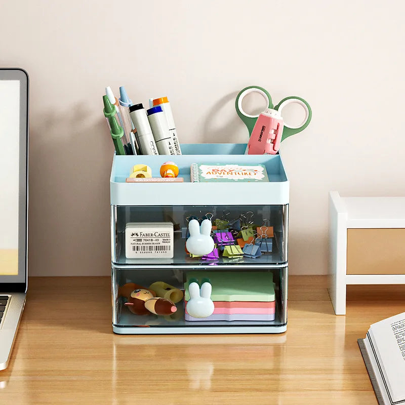 Front view of blue two-drawer desk organizer holding pens, scissors, clips, and sticky notes on a desk