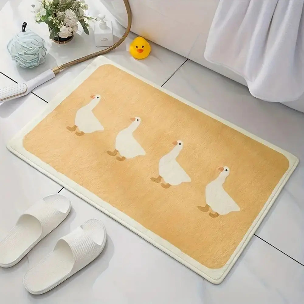 Beige duck bath mat with four white ducks, styled in a bathroom with slippers and a rubber duck