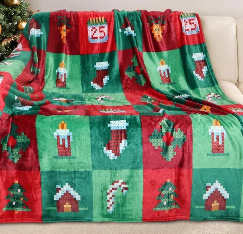 Green and red Christmas throw blanket with pixel-art pattern design on a sofa