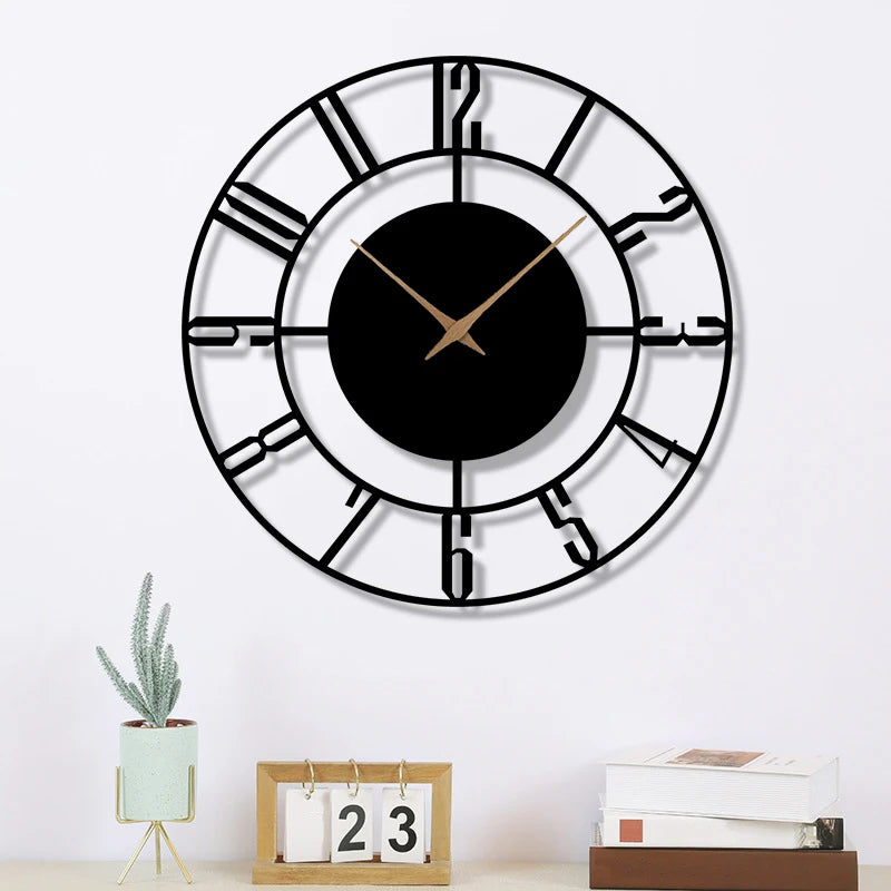 Minimalist black wall clock with open Arabic numerals on white wall above decorative items
