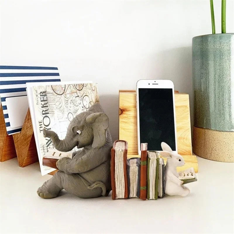 Bookend with elephant and rabbit figures holding books, styled with stationery