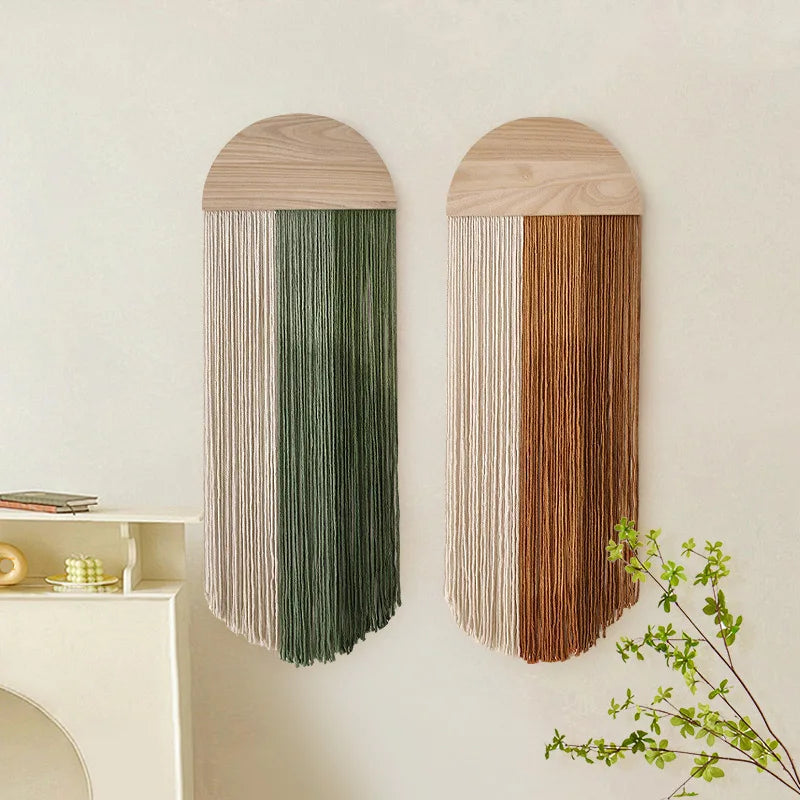 Semi-circular woven wall hangings with green and brown tassels in a living room setting