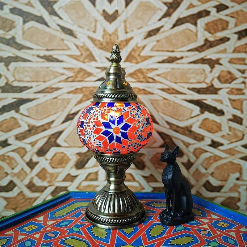 Stained glass mosaic table lamp with red and blue mosaic shade on patterned table