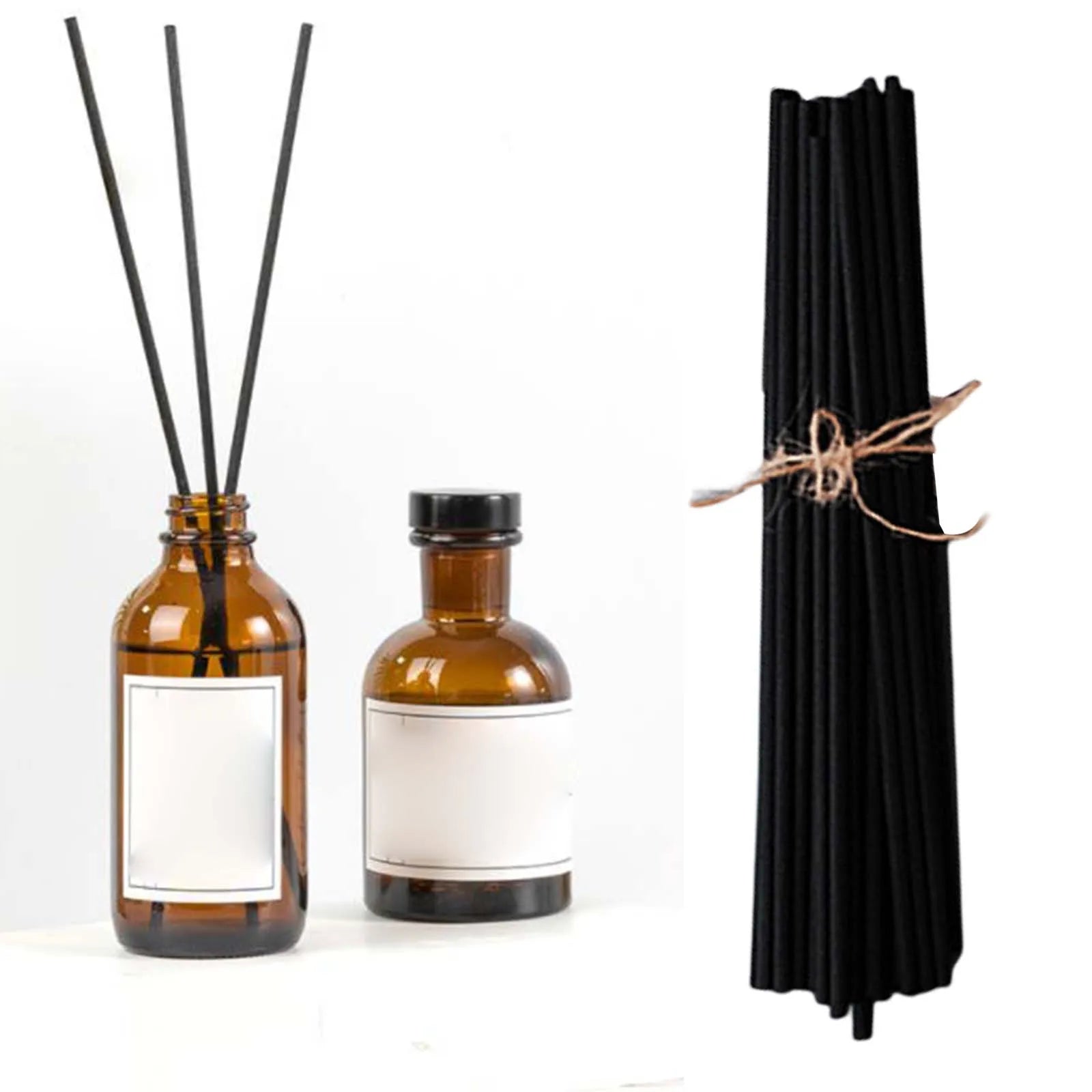 Black reed sticks displayed beside brown glass diffuser bottles, with several sticks inside one bottle