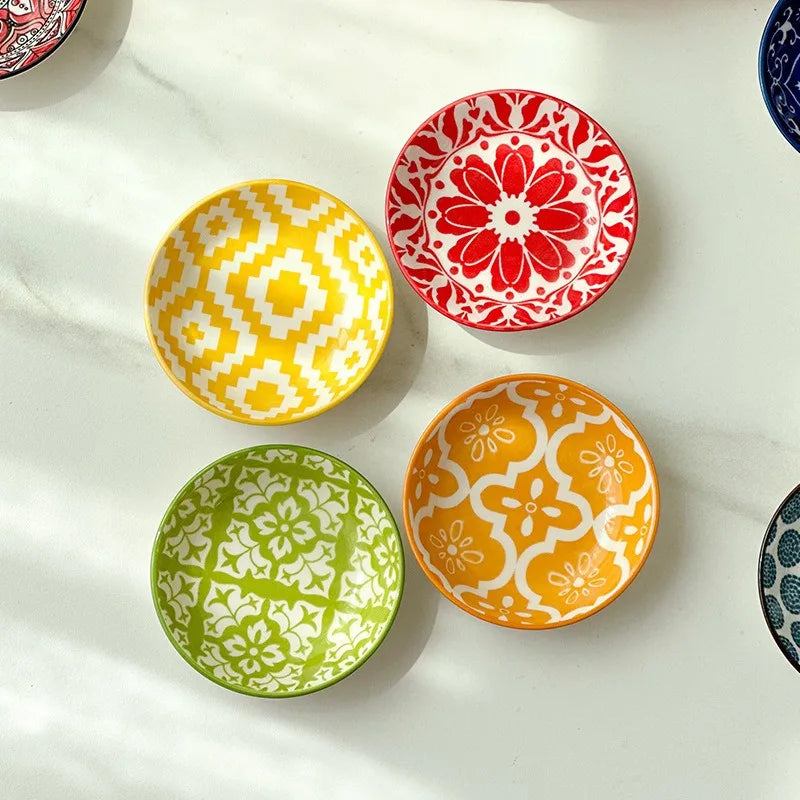 Four colorful mini ceramic trinket dishes with mandala patterns in yellow, green, orange, and red