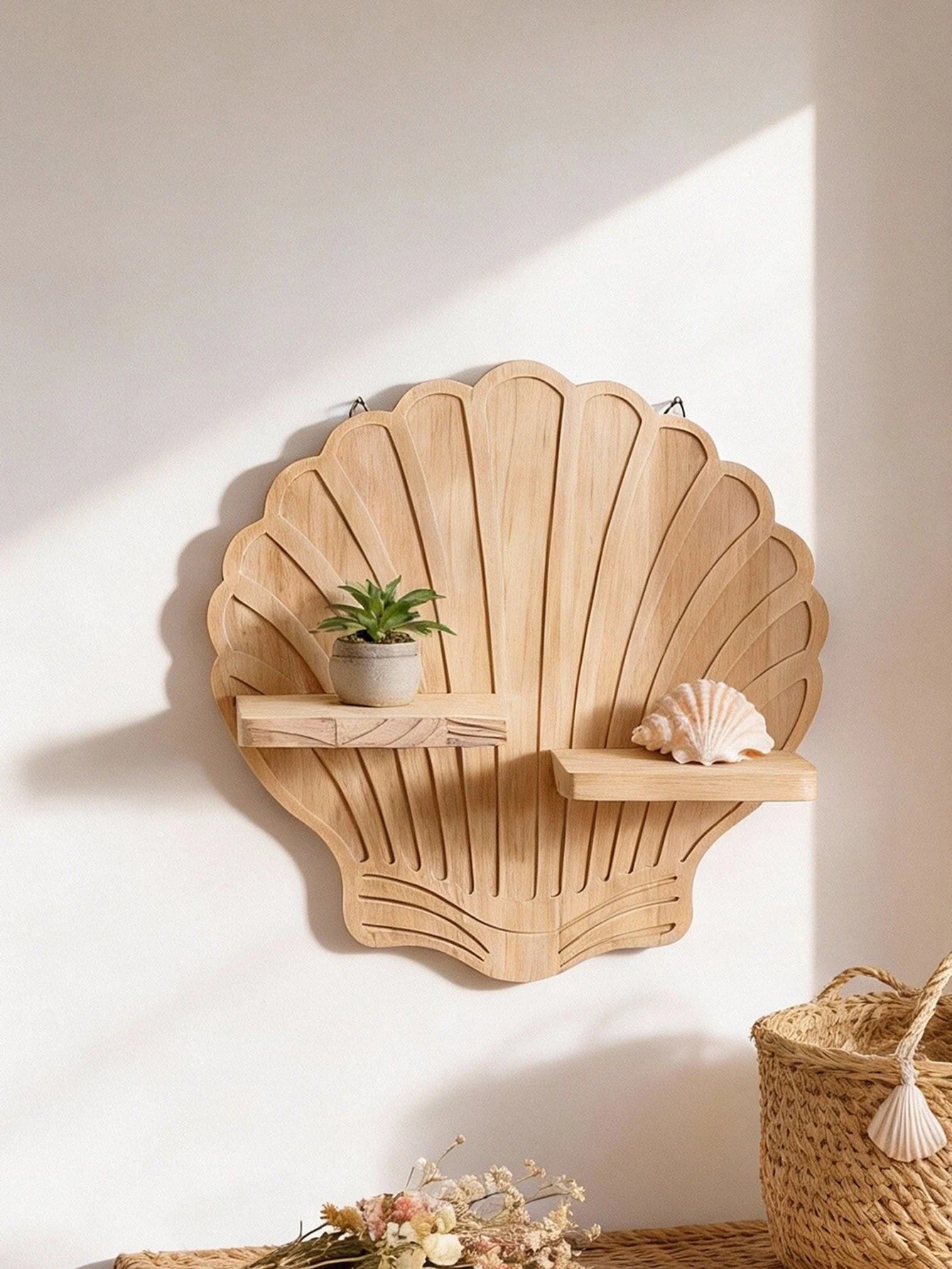 Close-up of the seashell wooden wall shelf displaying a small potted plant and a decorative shell—an example of coastal-inspired shelf styling.
