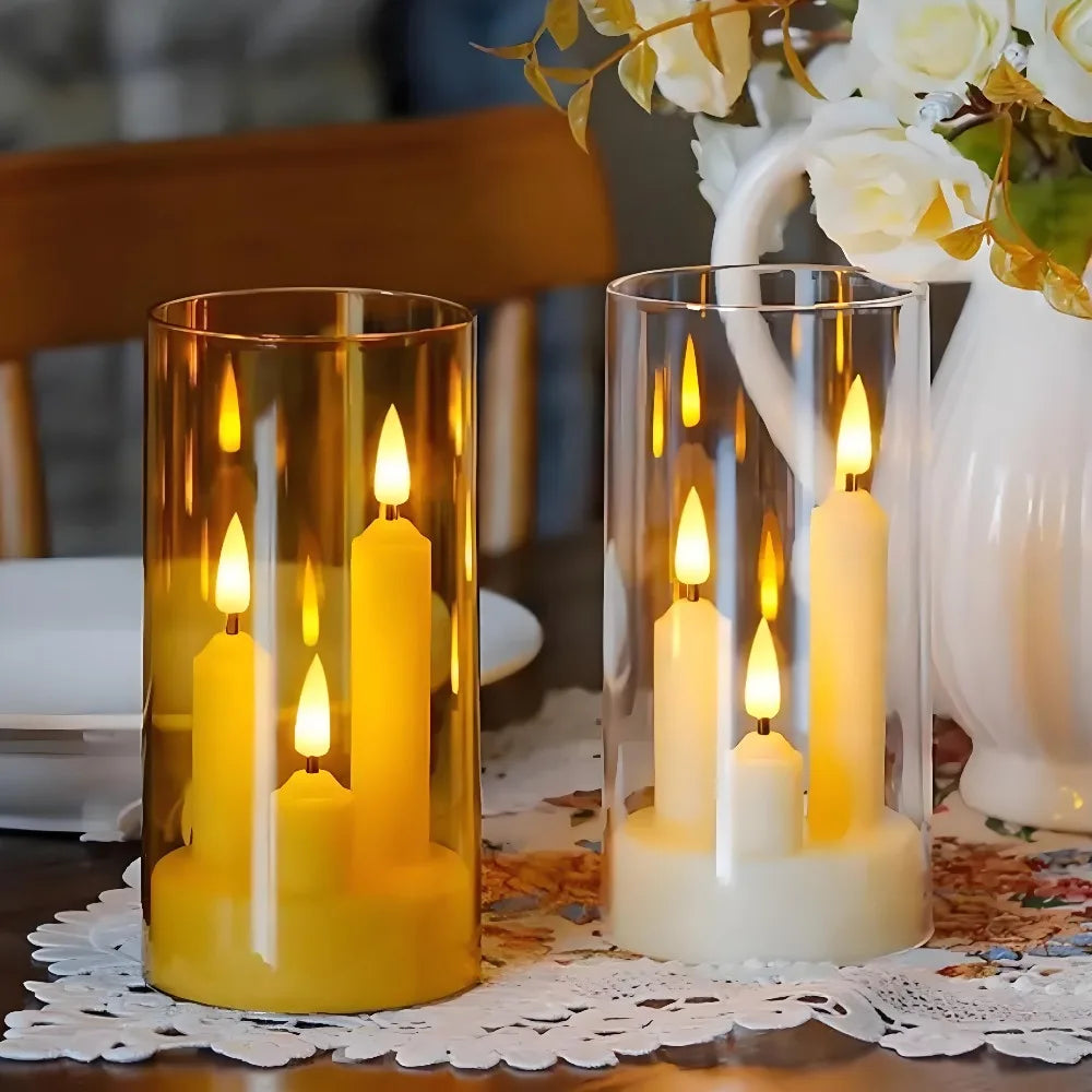 Gold and transparent cylinder flameless LED taper candle trios on a dining table with lace placemat and white flowers